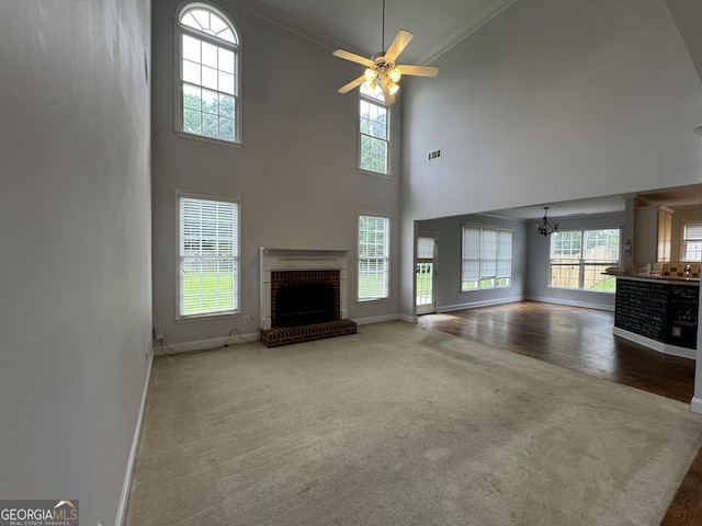 1031 Jordan Rd, Dacula, GA 30019 - unfurnished living room with carpet flooring, baseboards, healthy amount of natural light, a brick fireplace, and crown molding