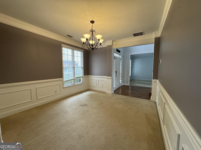 1031 Jordan Rd, Dacula, GA 30019 - unfurnished dining area featuring crown molding, light carpet, a decorative wall, a chandelier, and a wainscoted wall