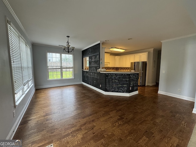 1031 Jordan Rd, Dacula, GA 30019 - unfurnished living room featuring crown molding, a chandelier, baseboards, and dark wood-style floors
