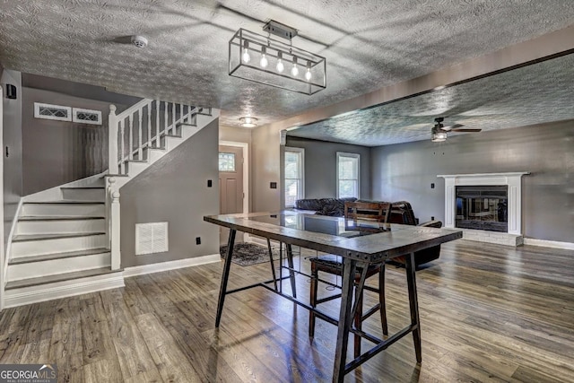 108 Country Acres Ct, Mcdonough, GA 30253 - dining room featuring wood finished floors, a ceiling fan, stairs, baseboards, and a textured ceiling
