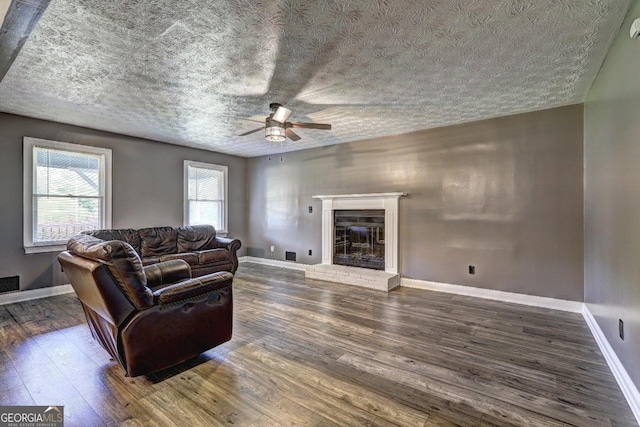 108 Country Acres Ct, Mcdonough, GA 30253 - living area with a ceiling fan, wood finished floors, a brick fireplace, baseboards, and a textured ceiling