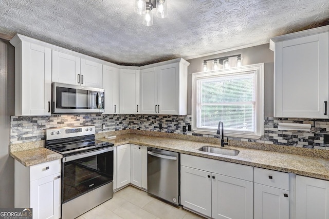 108 Country Acres Ct, Mcdonough, GA 30253 - kitchen with appliances with stainless steel finishes, a sink, tasteful backsplash, white cabinetry, and light tile patterned floors