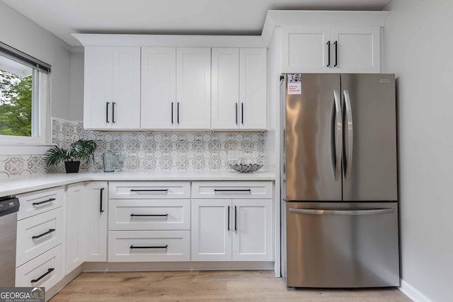 2012 Variations Dr NE, Atlanta, GA 30329 - kitchen featuring appliances with stainless steel finishes, light countertops, white cabinetry, tasteful backsplash, and light wood-type flooring