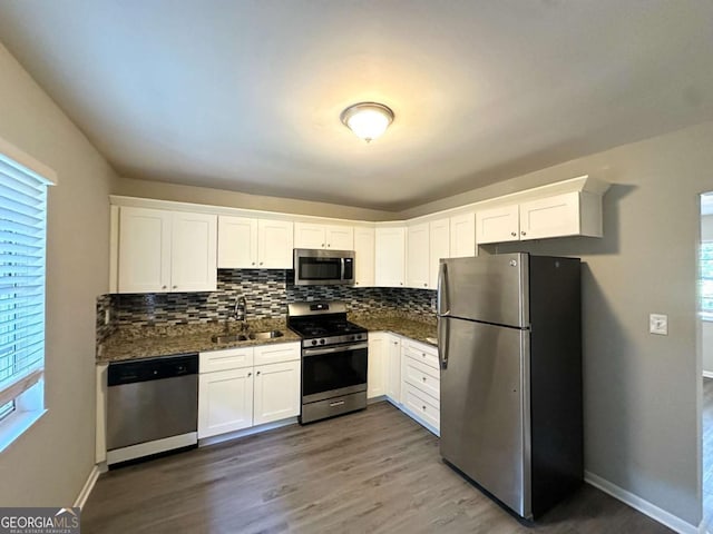 4039 Codel St NW, Atlanta, GA 30331 - kitchen with appliances with stainless steel finishes, a sink, white cabinets, tasteful backsplash, and healthy amount of natural light