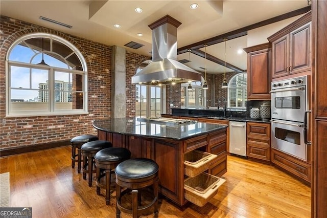 3180 Mathieson Dr NE Unit 1401, Atlanta, GA 30305 - kitchen featuring appliances with stainless steel finishes, a sink, brick wall, light wood-style floors, and plenty of natural light