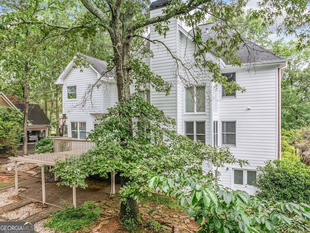 5190 Beech Forest Dr, Lilburn, GA 30047 - view of property exterior with roof with shingles, a deck, and a chimney