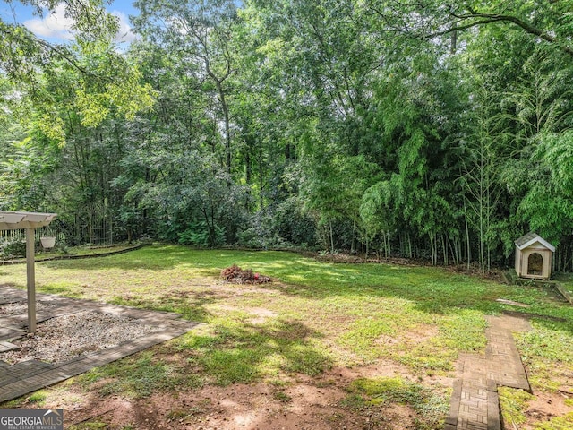 5190 Beech Forest Dr, Lilburn, GA 30047 - view of grassy yard featuring a shed and a wooded view