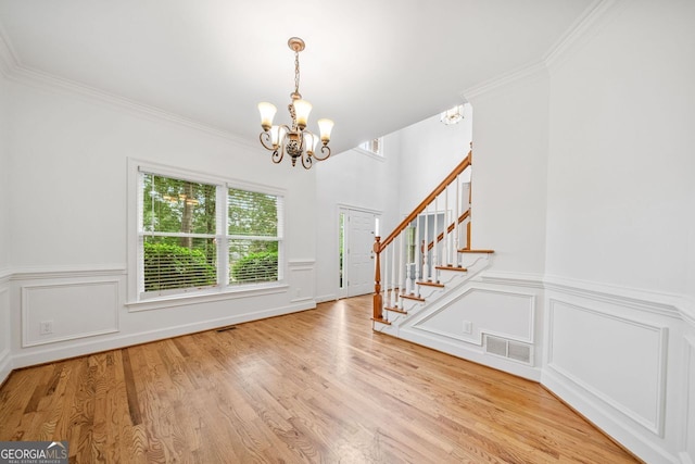 5190 Beech Forest Dr, Lilburn, GA 30047 - entrance foyer featuring a chandelier, stairway, wood finished floors, a decorative wall, and wainscoting