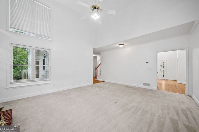 5190 Beech Forest Dr, Lilburn, GA 30047 - unfurnished living room with carpet floors, a towering ceiling, baseboards, crown molding, and a ceiling fan