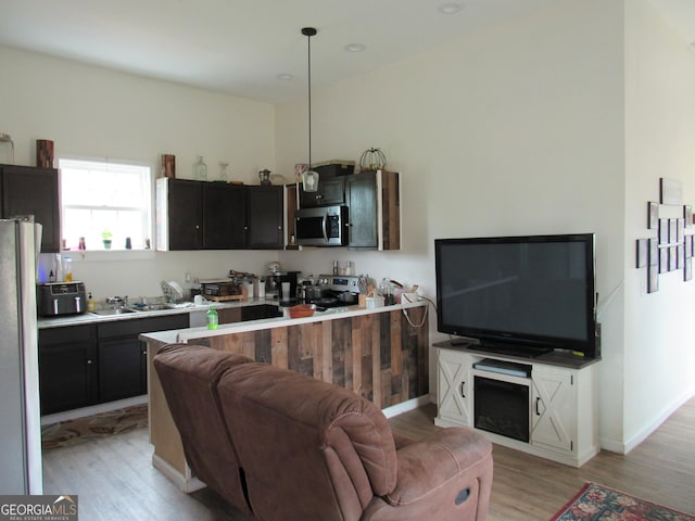 791 Anderson St, Macon, GA 31201 - kitchen featuring stainless steel appliances, light wood-type flooring, open floor plan, a sink, and light countertops