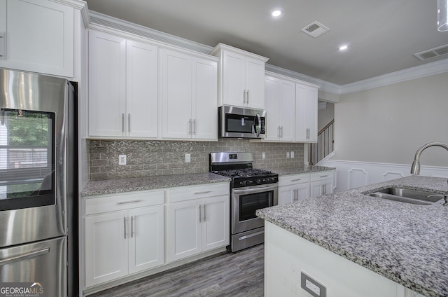 158 Bryon Ln, Acworth, GA 30102 - kitchen featuring stainless steel appliances, a sink, ornamental molding, white cabinetry, and light stone countertops