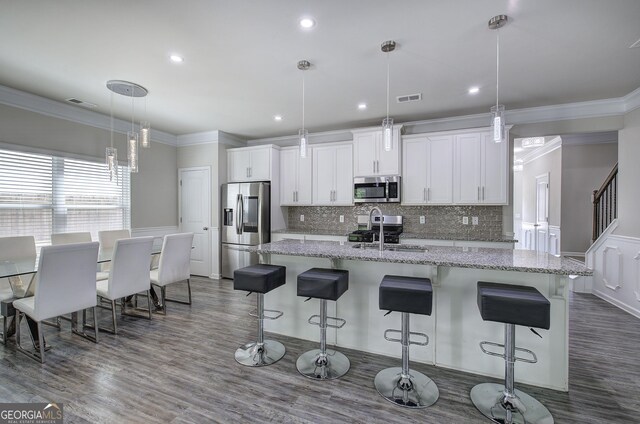158 Bryon Ln, Acworth, GA 30102 - kitchen featuring appliances with stainless steel finishes, a sink, crown molding, a center island with sink, and white cabinets