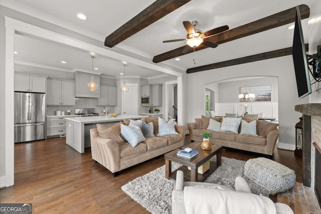 1104 Victoria St NE, Atlanta, GA 30319 - living area with arched walkways, beam ceiling, dark wood-style floors, ceiling fan, and a chandelier