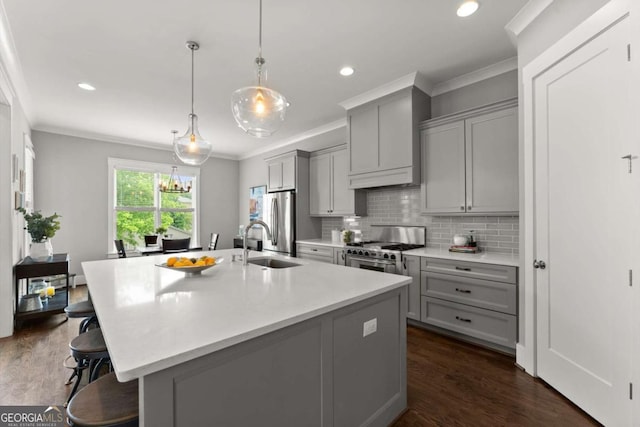 1104 Victoria St NE, Atlanta, GA 30319 - kitchen featuring gray cabinets, appliances with stainless steel finishes, crown molding, a breakfast bar, and an island with sink