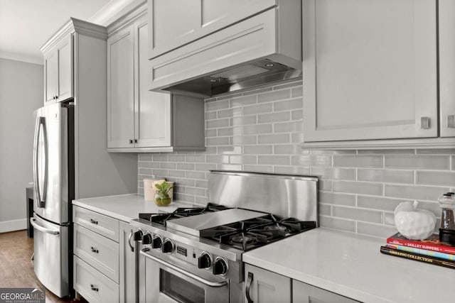 1104 Victoria St NE, Atlanta, GA 30319 - kitchen featuring appliances with stainless steel finishes, custom range hood, light countertops, tasteful backsplash, and wood finished floors