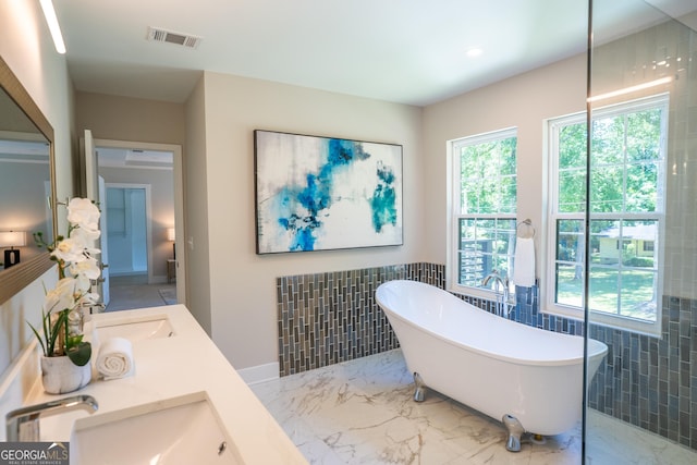 4366 Bradley Dr SW, Snellville, GA 30039 - full bath featuring tile walls, a freestanding bath, double vanity, a wainscoted wall, and marble finish floors
