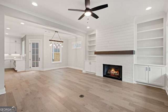 4002 Potter Way, Woodstock, GA 30188 - unfurnished living room featuring baseboards, a ceiling fan, a fireplace, light wood-style flooring, and built in shelves