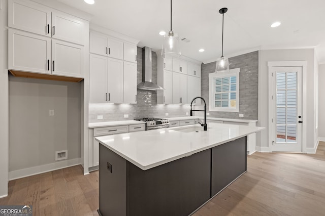 4002 Potter Way, Woodstock, GA 30188 - kitchen featuring wall chimney exhaust hood, stainless steel gas stove, a sink, light wood-style floors, and baseboards