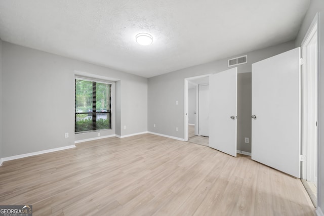 113 Tuxworth Cir, Decatur, GA 30033 - unfurnished bedroom with light wood-style flooring, baseboards, and a textured ceiling