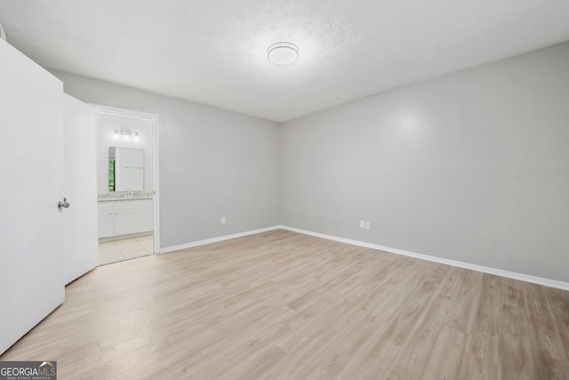 113 Tuxworth Cir, Decatur, GA 30033 - empty room with light wood-style floors, baseboards, a sink, and a textured ceiling