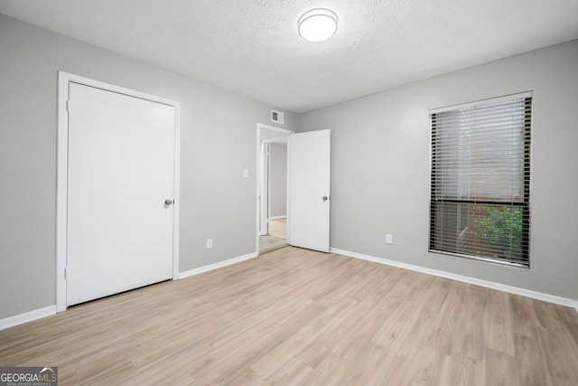 113 Tuxworth Cir, Decatur, GA 30033 - unfurnished bedroom with light wood finished floors, baseboards, and a textured ceiling