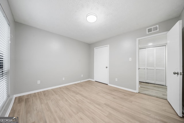113 Tuxworth Cir, Decatur, GA 30033 - unfurnished bedroom featuring light wood-style floors, baseboards, and a textured ceiling
