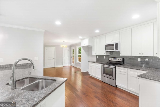 347 Chip Rd, Stone Mountain, GA 30087 - kitchen with appliances with stainless steel finishes, a sink, ornamental molding, dark stone counters, and white cabinetry