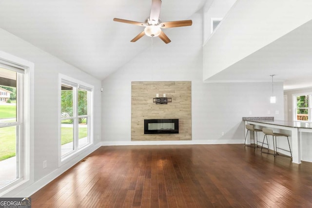 347 Chip Rd, Stone Mountain, GA 30087 - unfurnished living room with hardwood / wood-style floors, ceiling fan, a fireplace, baseboards, and high vaulted ceiling
