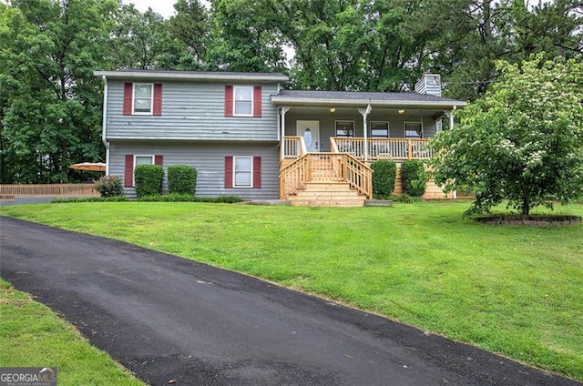 123 Mill Ln, Dallas, GA 30157 - split level home featuring a porch, a chimney, a front yard, and view of scattered trees