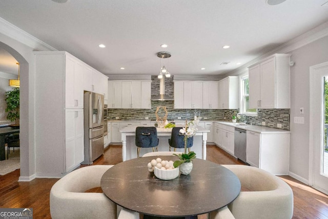 667 Creswell Park, Smyrna, GA 30082 - kitchen featuring wall chimney range hood, arched walkways, stainless steel appliances, ornamental molding, and backsplash
