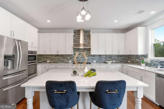 667 Creswell Park, Smyrna, GA 30082 - kitchen with stainless steel appliances, wall chimney range hood, a breakfast bar, white cabinets, and recessed lighting
