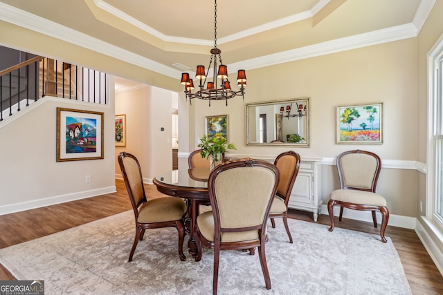 12645 Morningpark Cir, Alpharetta, GA 30004 - dining area with a chandelier, wood finished floors, a raised ceiling, crown molding, and baseboards