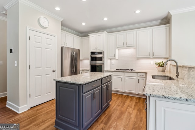 12645 Morningpark Cir, Alpharetta, GA 30004 - kitchen with appliances with stainless steel finishes, a sink, white cabinets, crown molding, and light wood-style floors