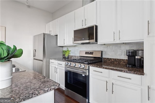 1195 Milton Ter SE Unit 5101, Atlanta, GA 30315 - kitchen featuring appliances with stainless steel finishes, white cabinets, backsplash, dark wood-style flooring, and dark stone counters