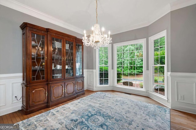 206 Kingsley Way, Woodstock, GA 30188 - dining space with a chandelier, crown molding, a wainscoted wall, wood finished floors, and a decorative wall