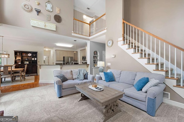206 Kingsley Way, Woodstock, GA 30188 - living room with stairs, a high ceiling, light carpet, and baseboards