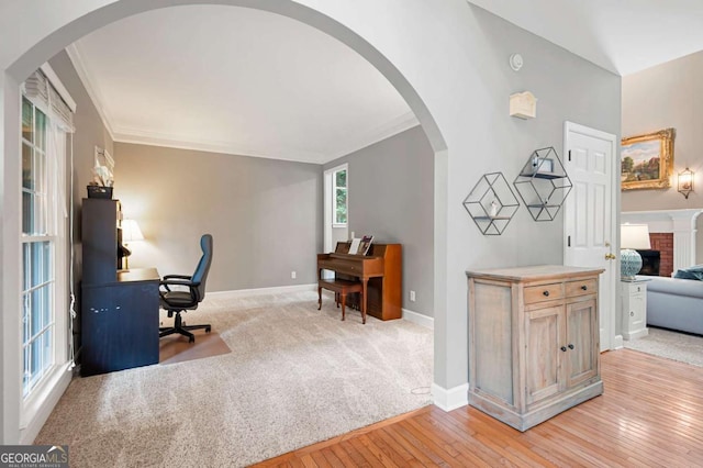 206 Kingsley Way, Woodstock, GA 30188 - office area featuring baseboards, light wood-style floors, arched walkways, crown molding, and a fireplace