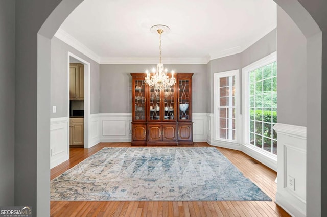 206 Kingsley Way, Woodstock, GA 30188 - dining room featuring hardwood / wood-style flooring, a chandelier, wainscoting, crown molding, and arched walkways