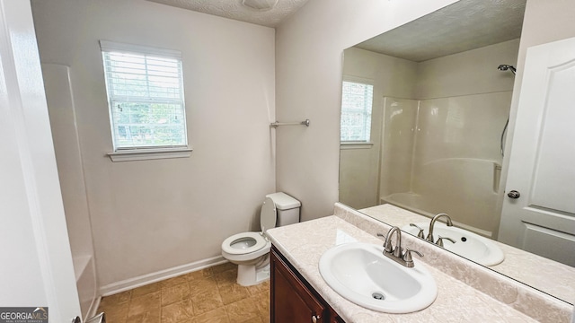 4676 Shaded Oak Ln, Forest Park, GA 30297 - full bathroom featuring toilet, vanity, plenty of natural light, baseboards, and a textured ceiling