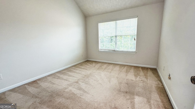 4676 Shaded Oak Ln, Forest Park, GA 30297 - carpeted empty room with baseboards, vaulted ceiling, and a textured ceiling