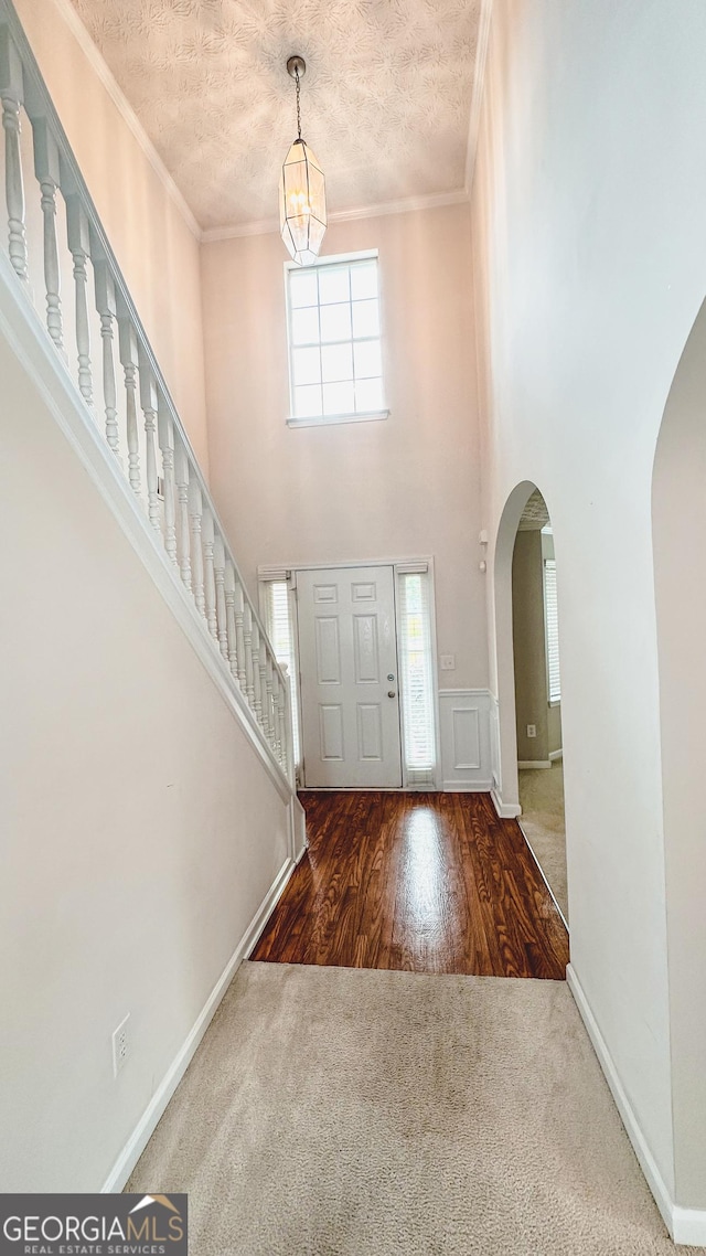 4676 Shaded Oak Ln, Forest Park, GA 30297 - foyer with arched walkways, carpet flooring, a textured ceiling, a chandelier, and ornamental molding