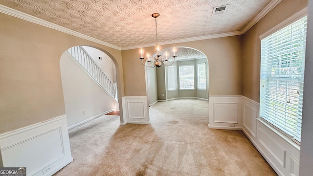 4676 Shaded Oak Ln, Forest Park, GA 30297 - unfurnished dining area featuring arched walkways, a chandelier, wainscoting, light carpet, and stairs
