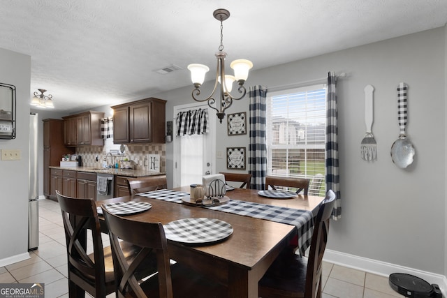 1195 New Hope Rd, Locust Grove, GA 30248 - dining room featuring light tile patterned floors, a chandelier, baseboards, and a textured ceiling