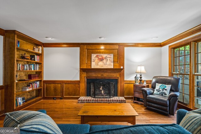 4506 Westcliff Trce NE, Roswell, GA 30075 - living area with a large fireplace, wood finished floors, a wainscoted wall, and crown molding