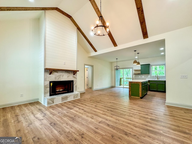 169 View St, Clarkesville, GA 30523 - unfurnished living room with a chandelier, light wood-style flooring, beam ceiling, high vaulted ceiling, and a high end fireplace