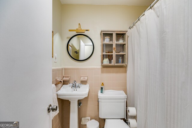 2575 Dobbs Dr NW, Kennesaw, GA 30152 - bathroom featuring tile walls, toilet, a wainscoted wall, and a sink
