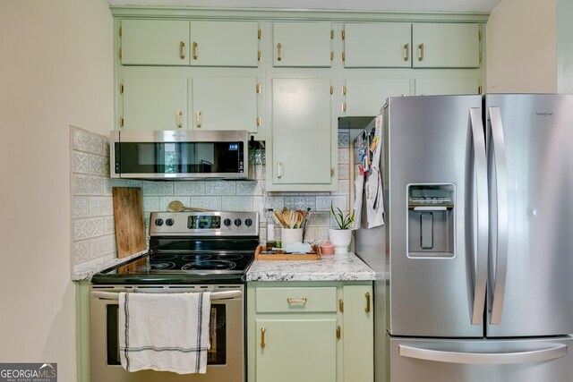 2575 Dobbs Dr NW, Kennesaw, GA 30152 - kitchen with stainless steel appliances, tasteful backsplash, light countertops, and green cabinets