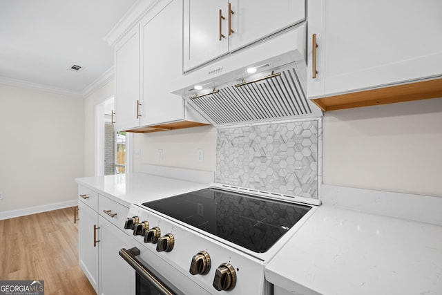 1905 Azalea, Valdosta, GA 31602 - kitchen with stove, under cabinet range hood, crown molding, tasteful backsplash, and white cabinets