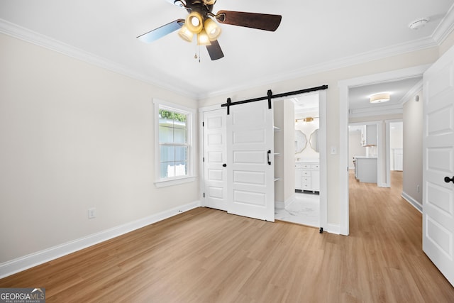 1905 Azalea, Valdosta, GA 31602 - unfurnished bedroom featuring a barn door, light wood-style flooring, ornamental molding, baseboards, and a ceiling fan