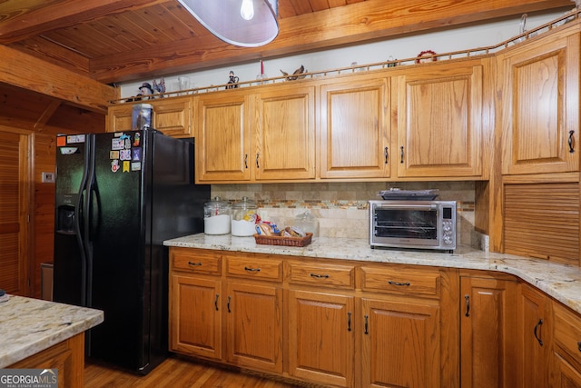 3382 Antioch Greggs Rd, Adel, GA 31620 - kitchen featuring black fridge with ice dispenser, wood ceiling with exposed beams, decorative backsplash, light wood-style flooring, and light stone counters